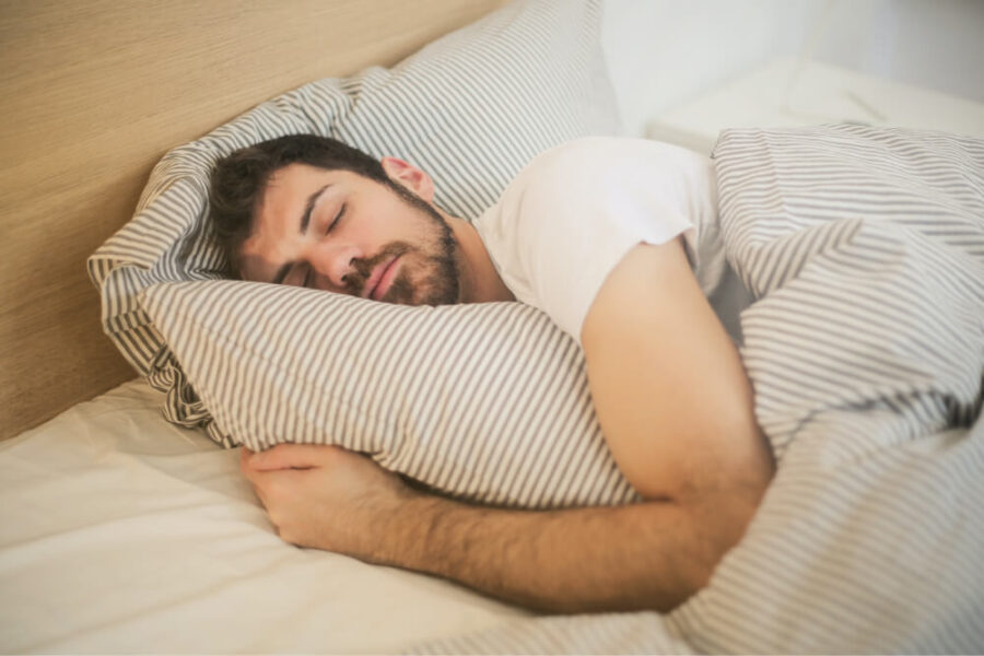 Man sleeping in his student apartment at The Green on Campus Drive